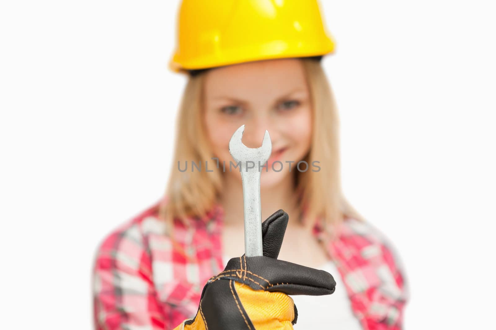 Woman presenting a wrench against white background
