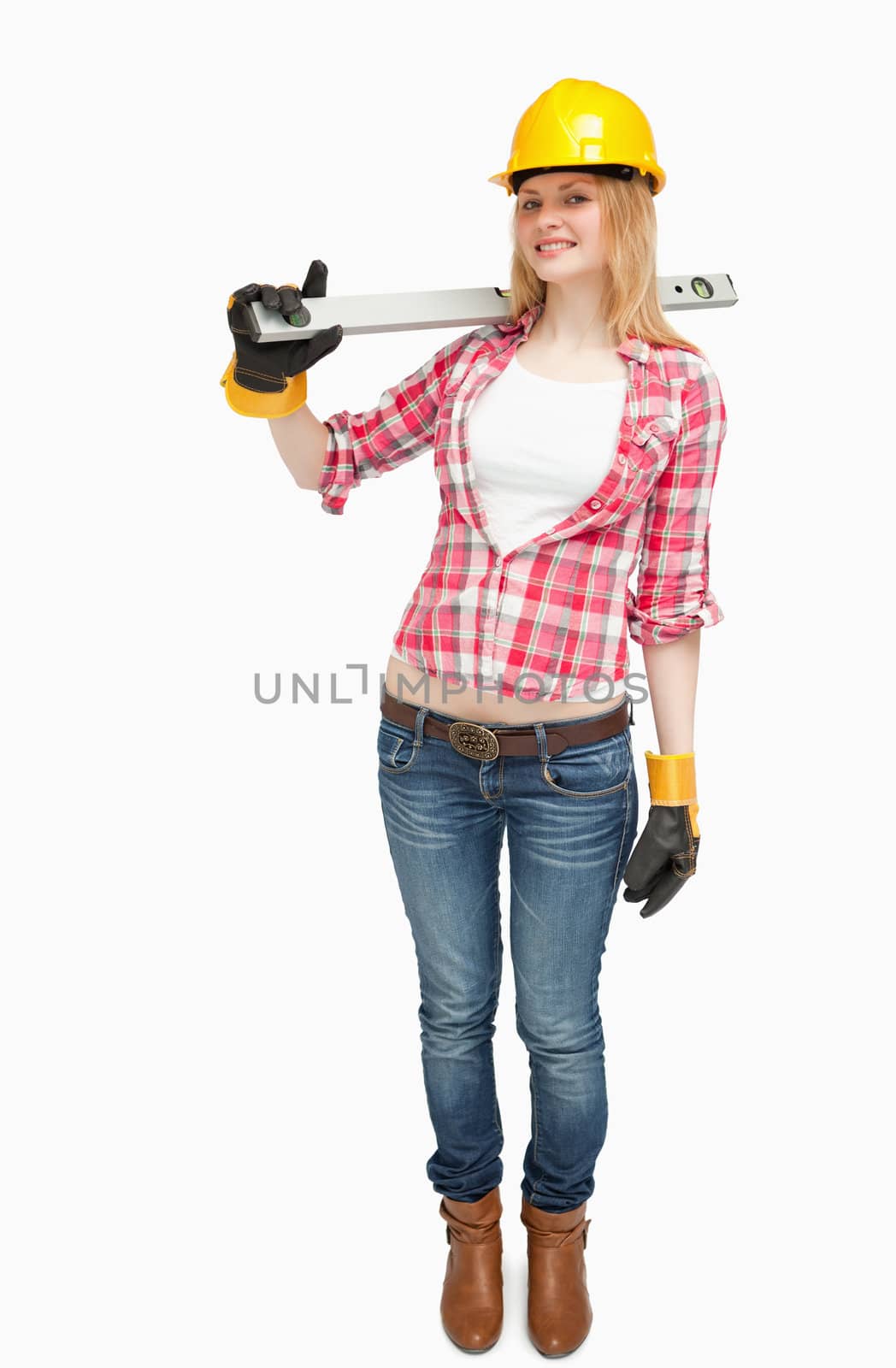 Joyful woman holding a spirit level against white background