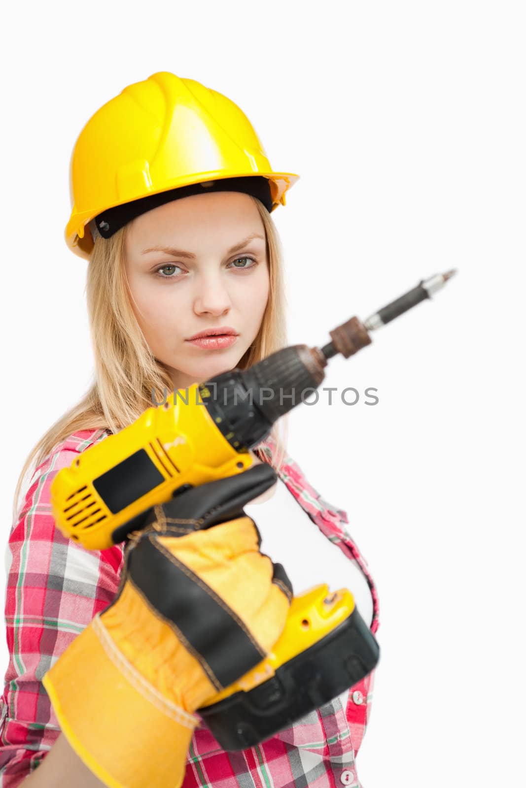 Serious woman holding an electric screwdriver against white background