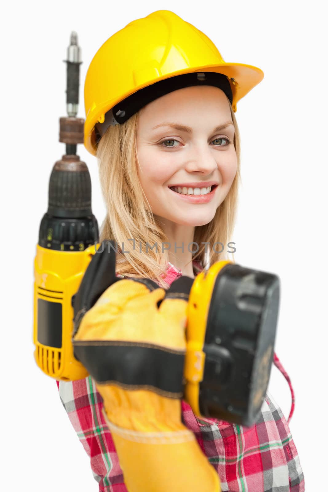 Smiling woman holding an electric screwdriver against white background