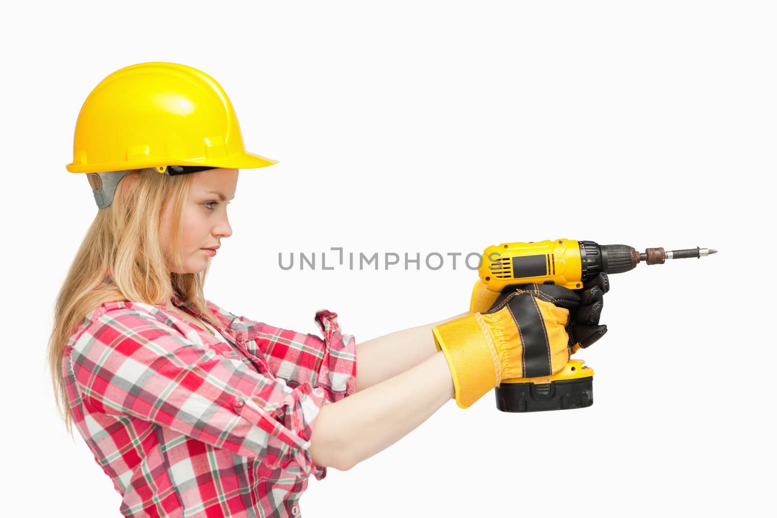 Serious woman using an electric screwdriver against white background