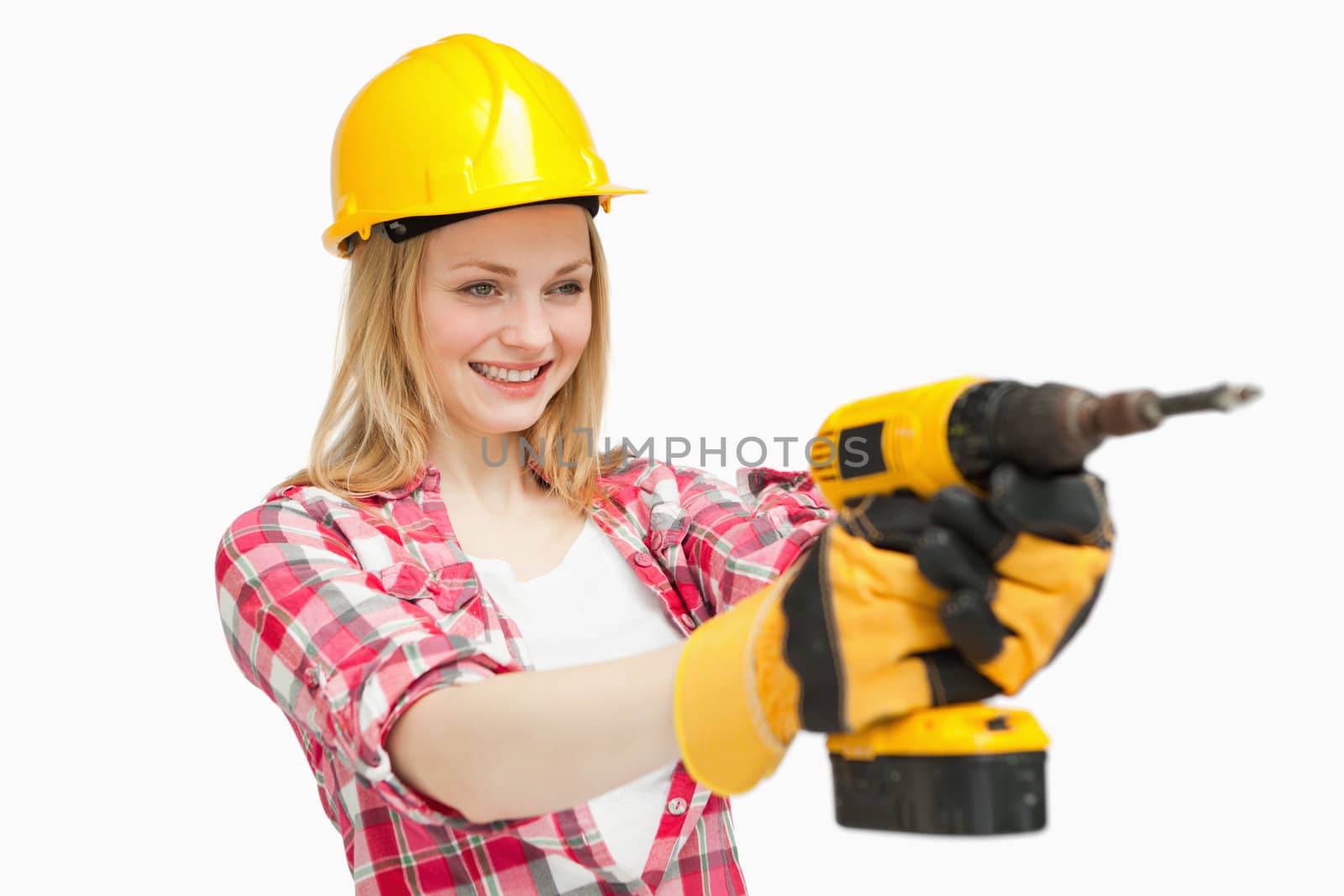 Joyful woman using an electric screwdriver against white background