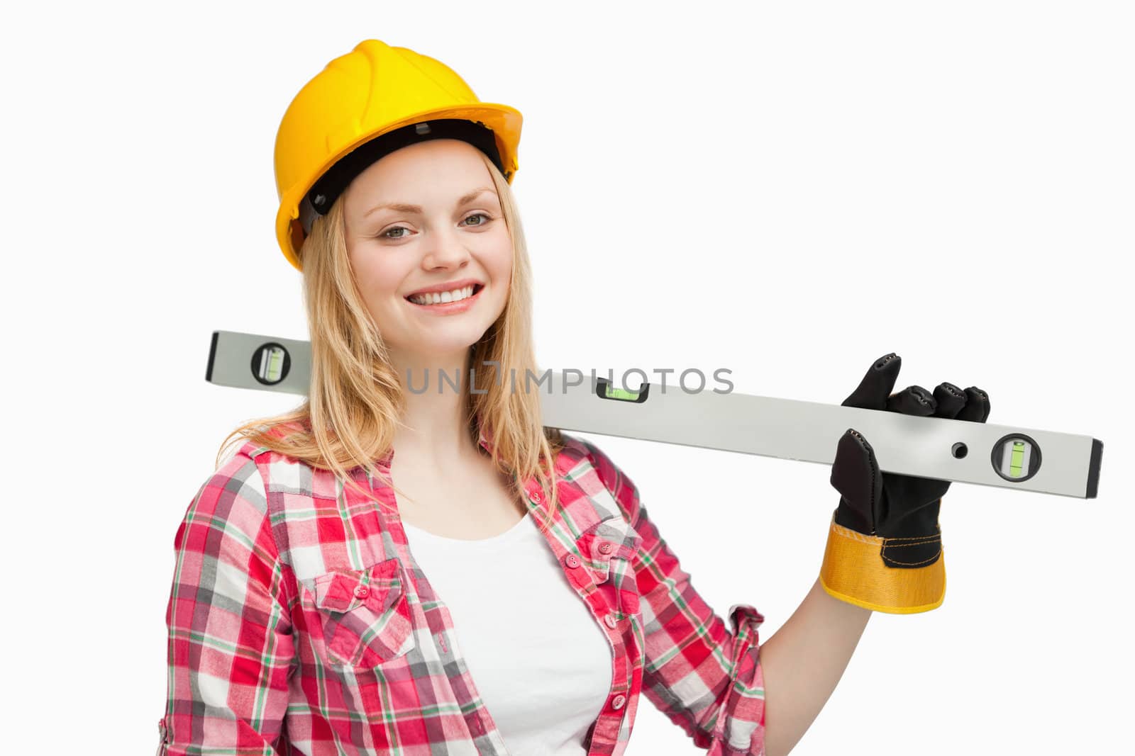 Smiling woman holding a spirit level against white background
