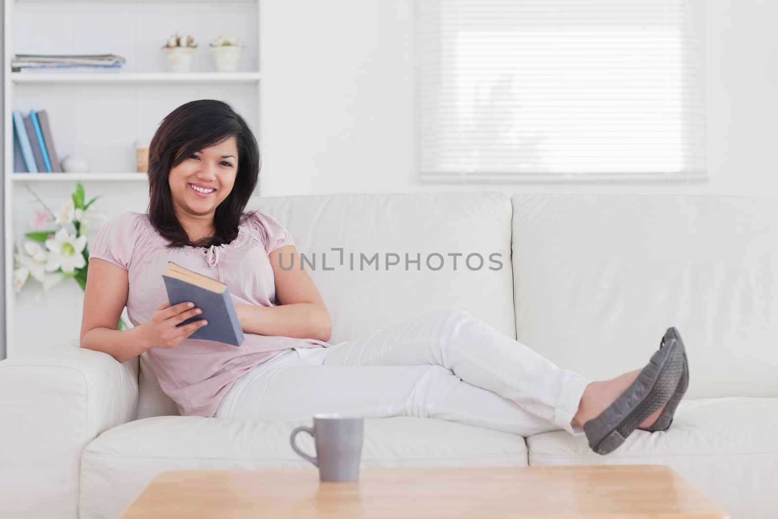 Smiling woman lying on a sofa in a living room