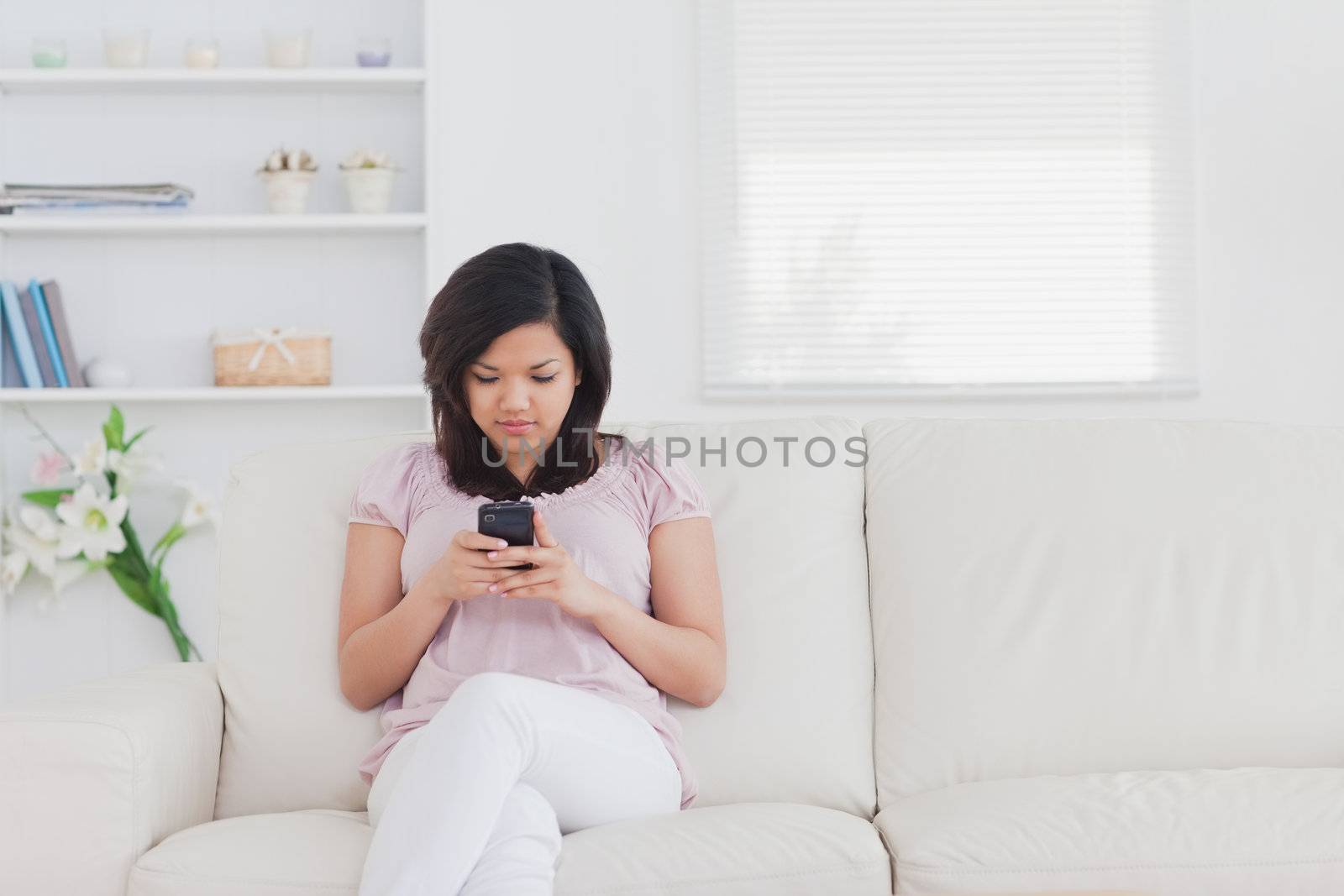 Woman holding a phone while sitting on a couch