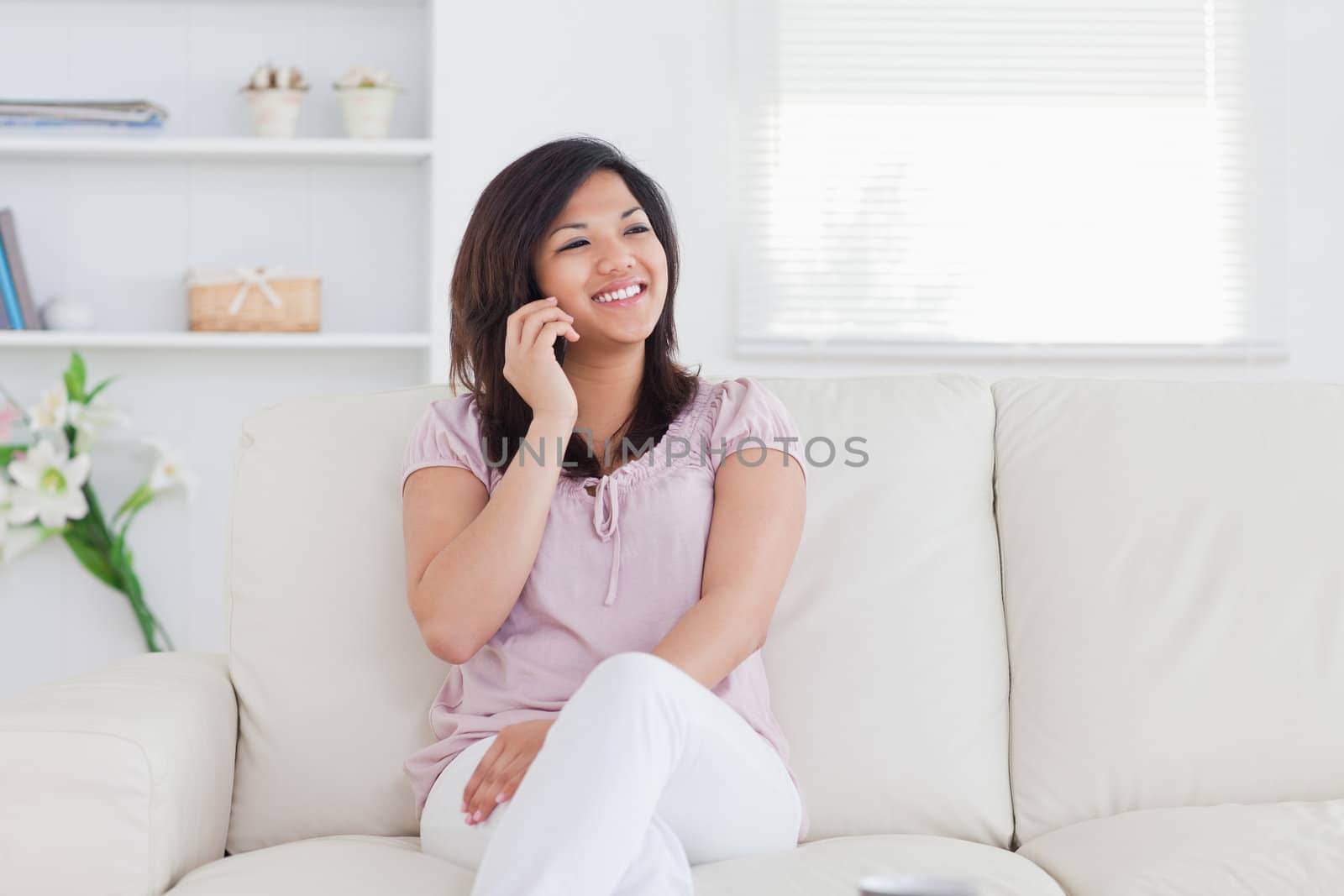 Woman smiling and phoning in a living room