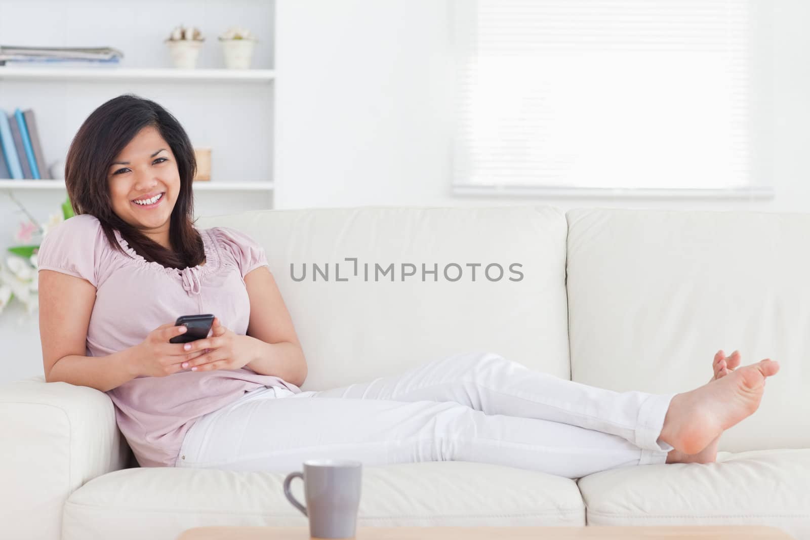 Woman smiling and lying on a couch in a living room