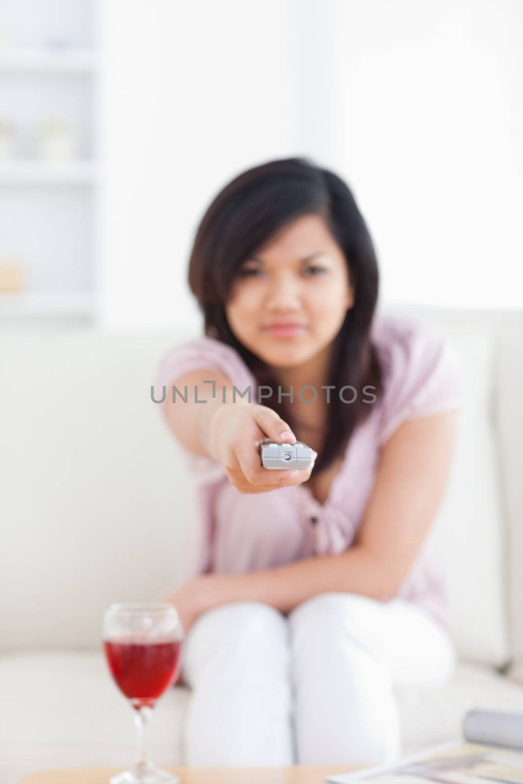 Blurred woman holding a television remote in a living room