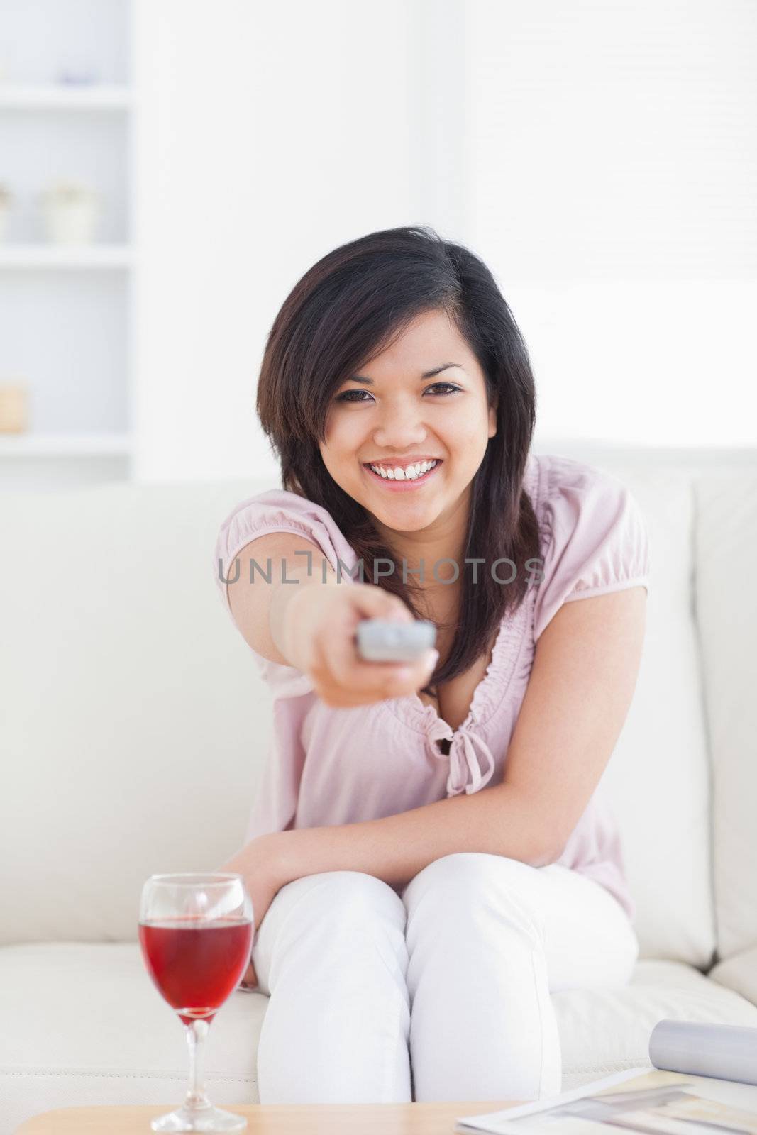 Woman smiling and holding a television remote in a living room