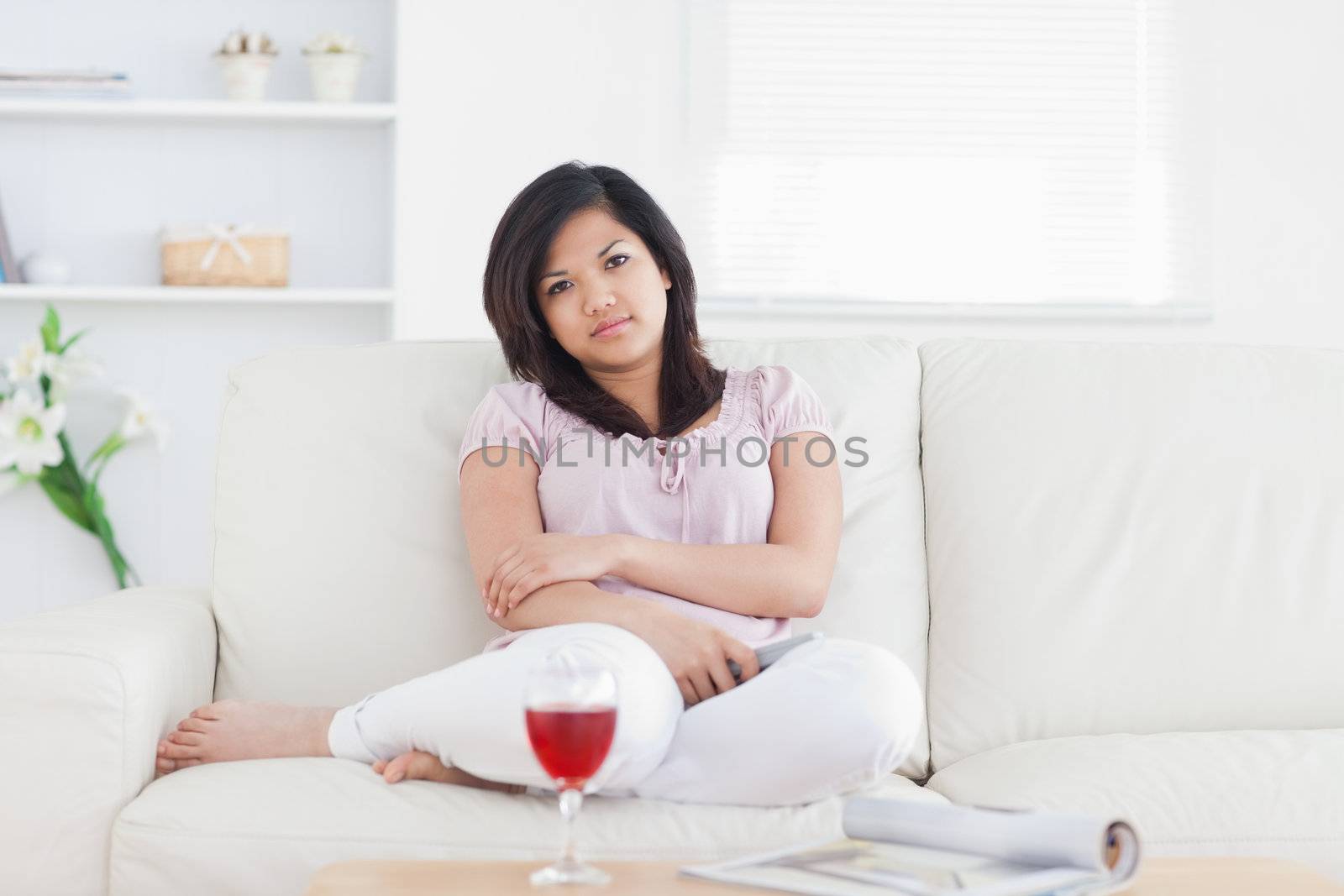 Woman sitting on a couch while crossing her arms in a living room