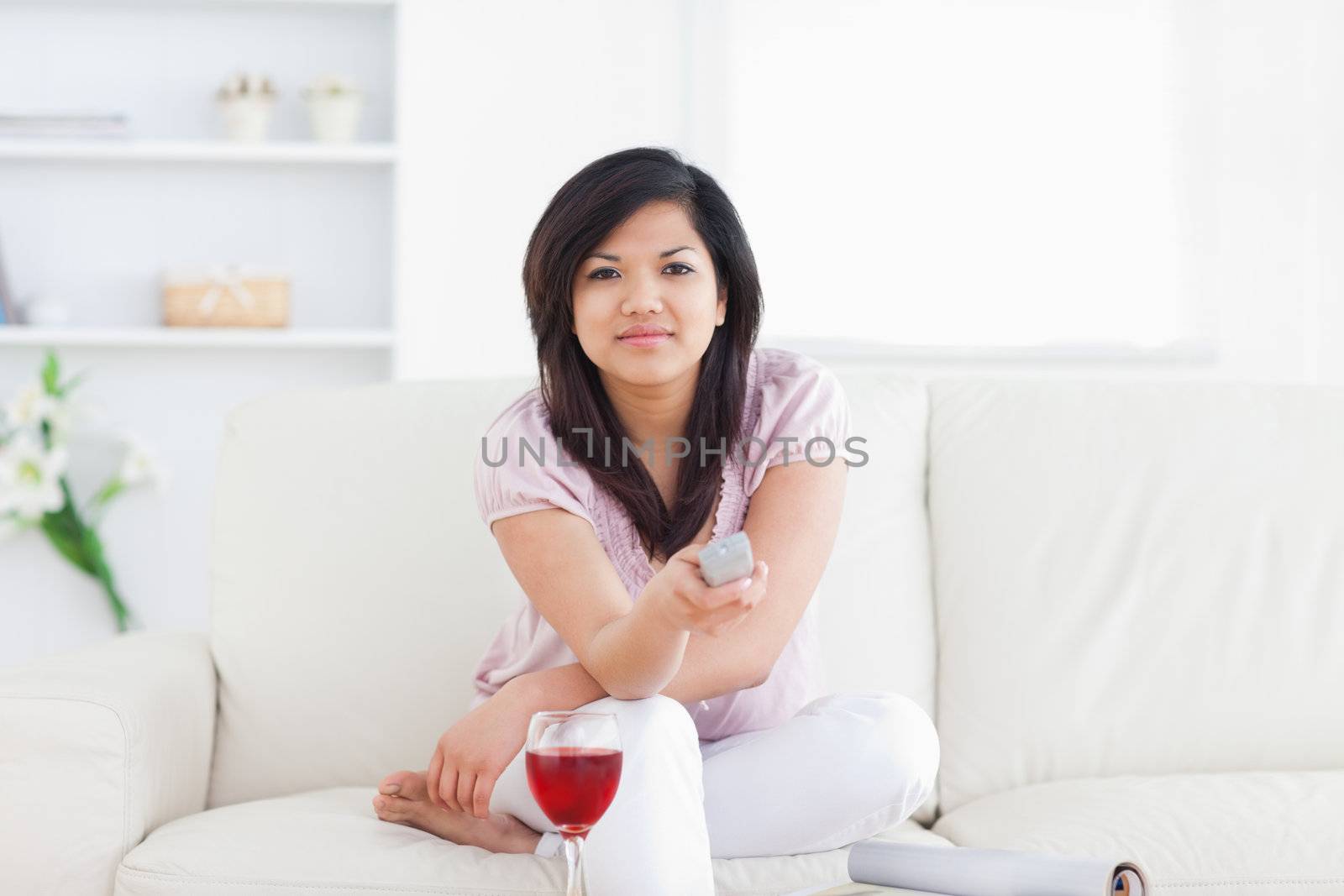 Woman sitting on a couch while holding a remote in a living room