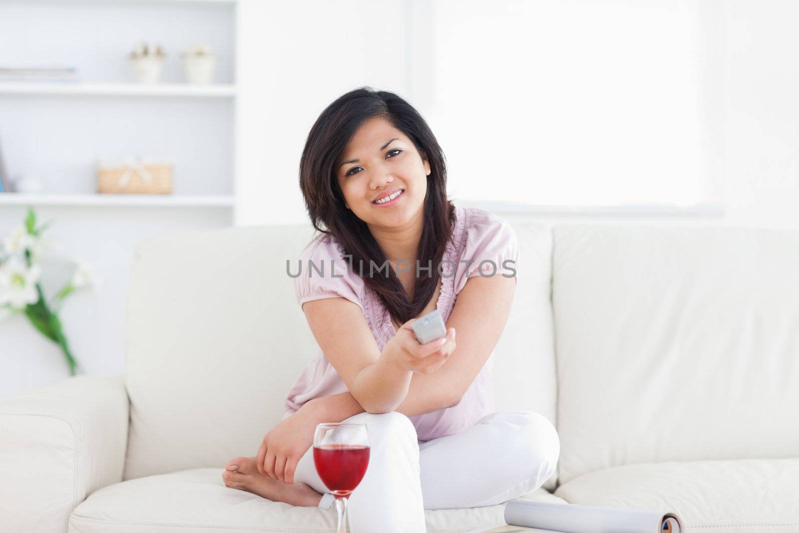 Woman sitting on a couch and holding a television in a living room