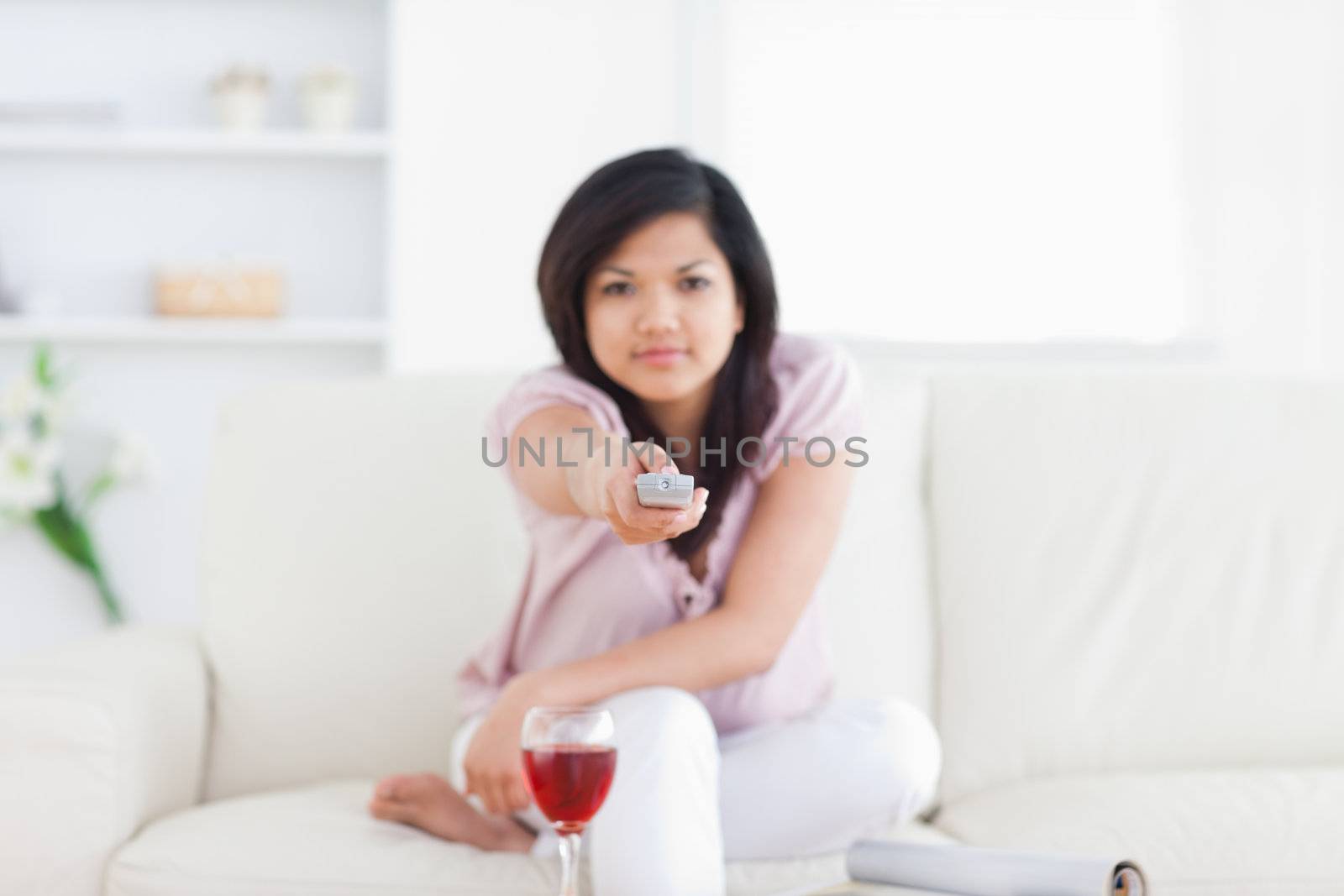 Woman pressing on a television remote in a living room