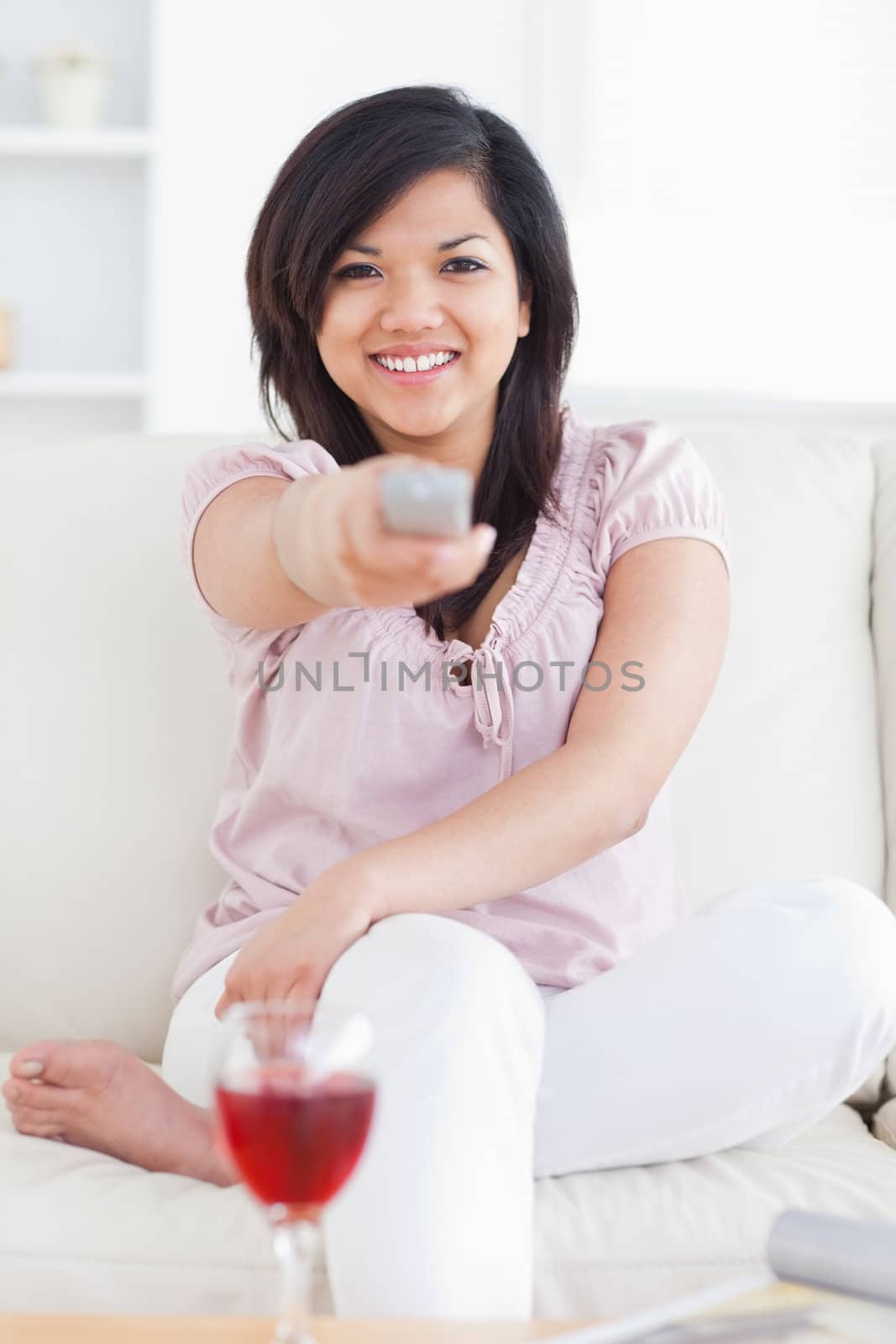 Woman crossing her legs and holding a remote in a living room