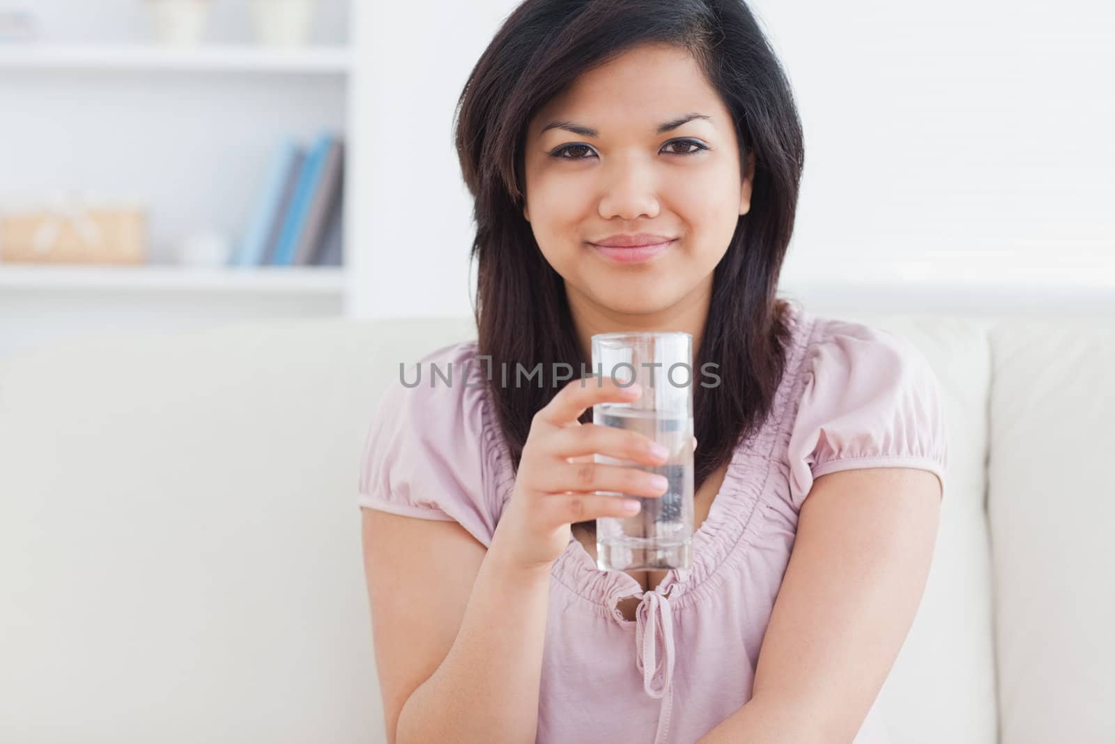 Woman holding a glass of water in a living room