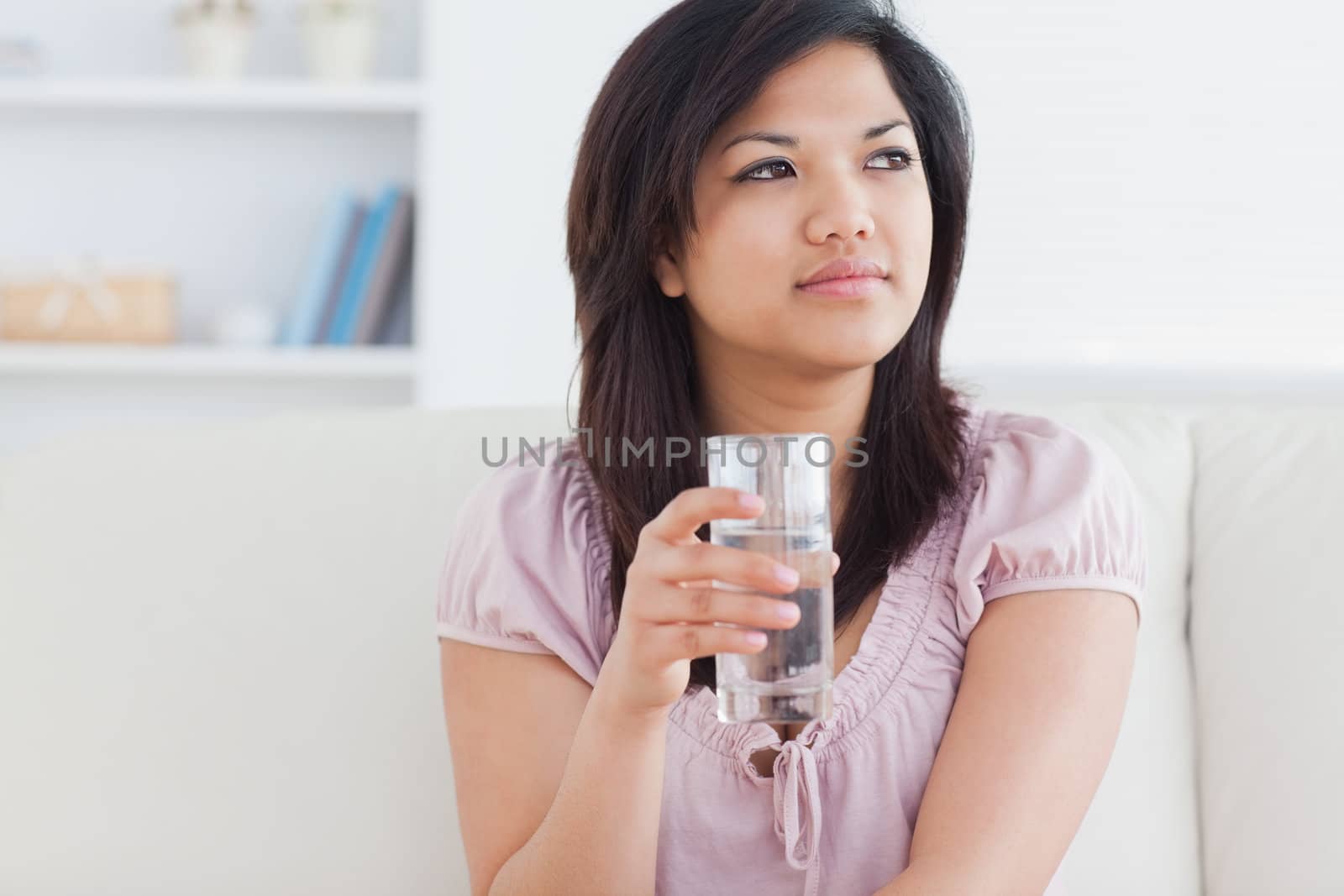 Woman sitting on a sofa and holding a glass in a living room