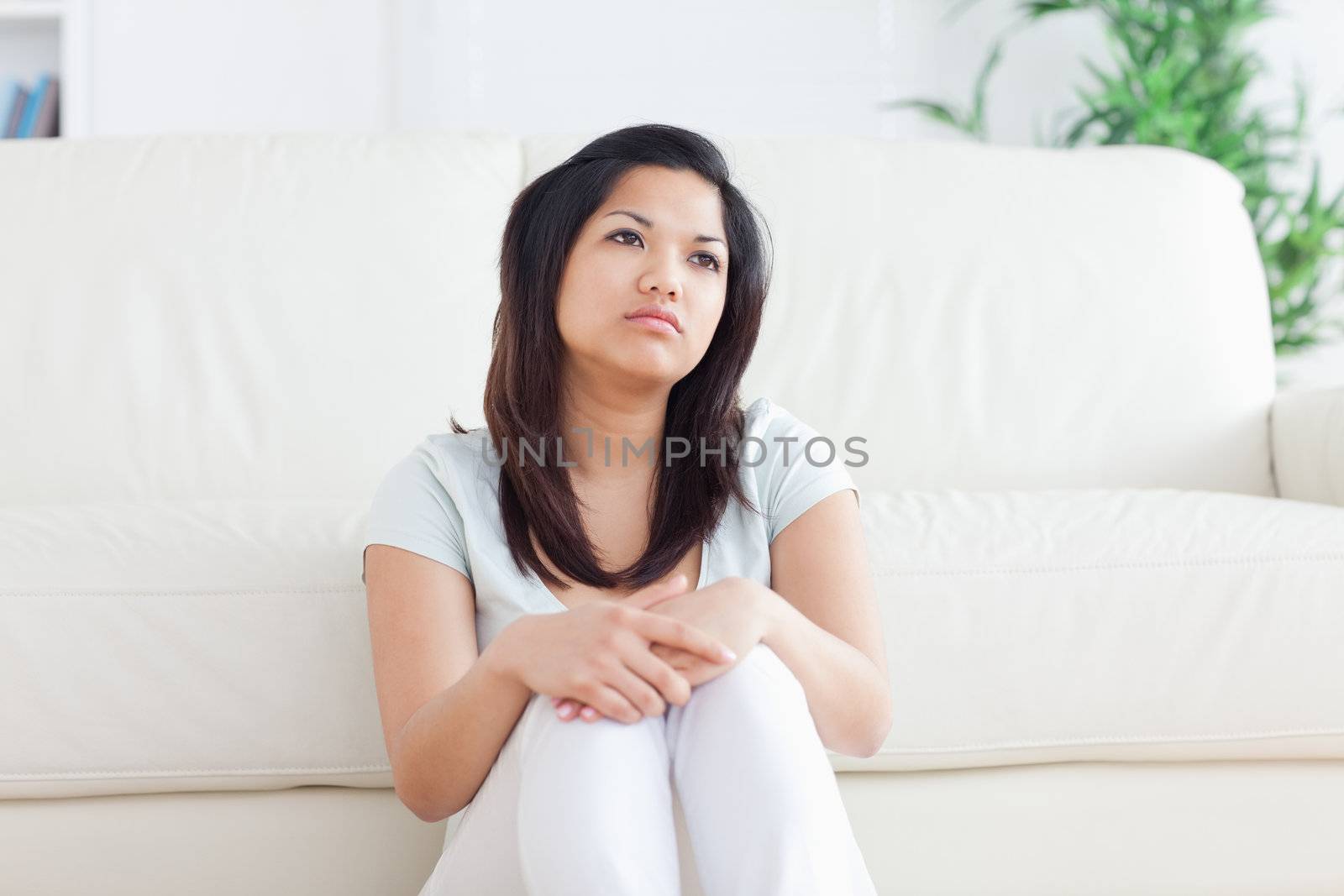 Woman is sitting in front of a couch in a living room