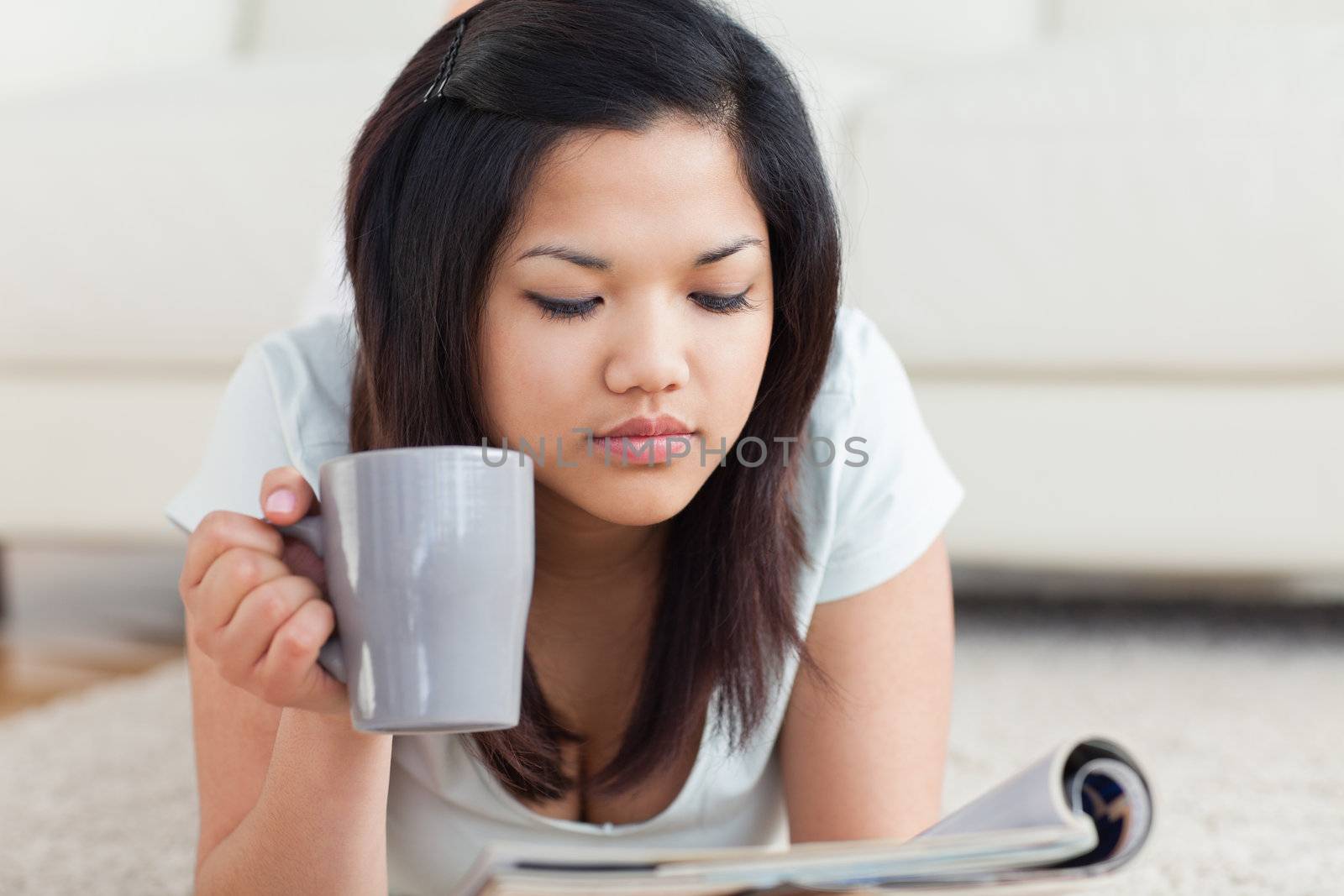 Woman holding a mug while reading a magazine in a living room