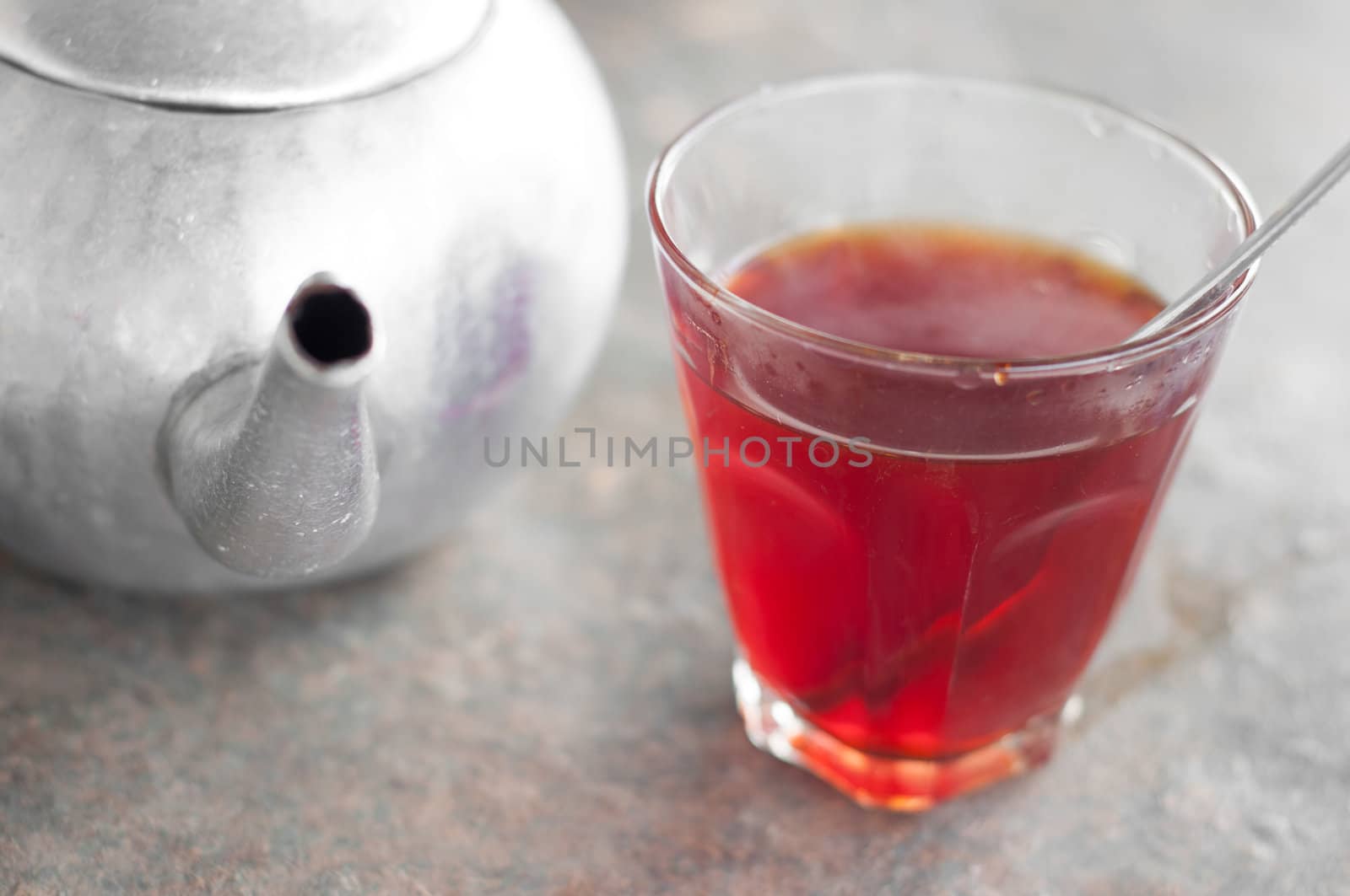 hot tea in glass on table with tea pot