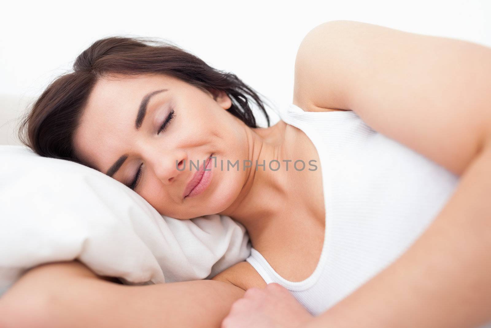 Peaceful woman lying while sleeping in the morning in her bedroom