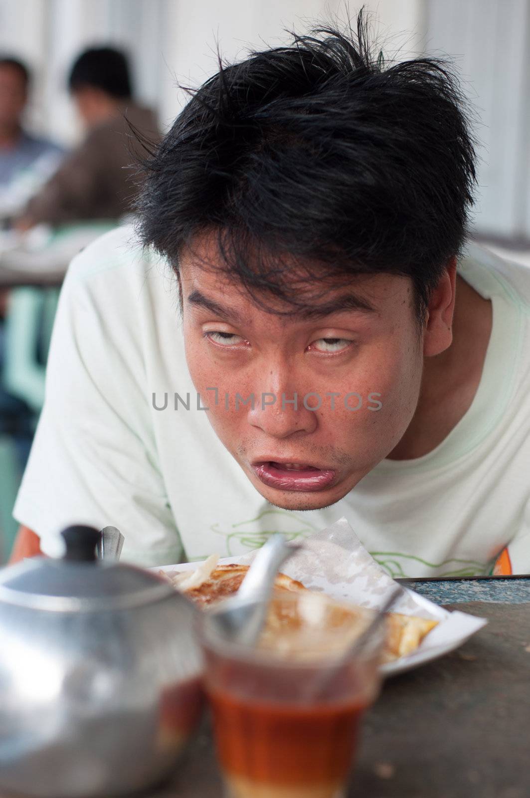 asian drunken man while having breakfast and tea