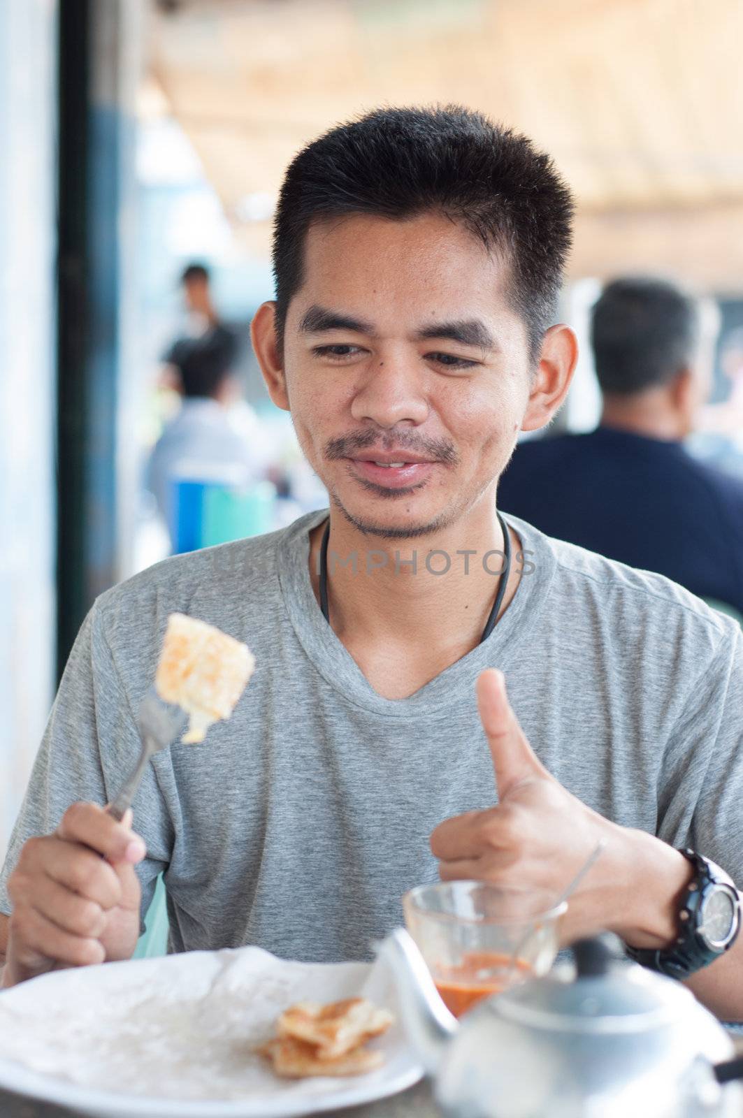 asian man enjoy eating breakfast by ngarare