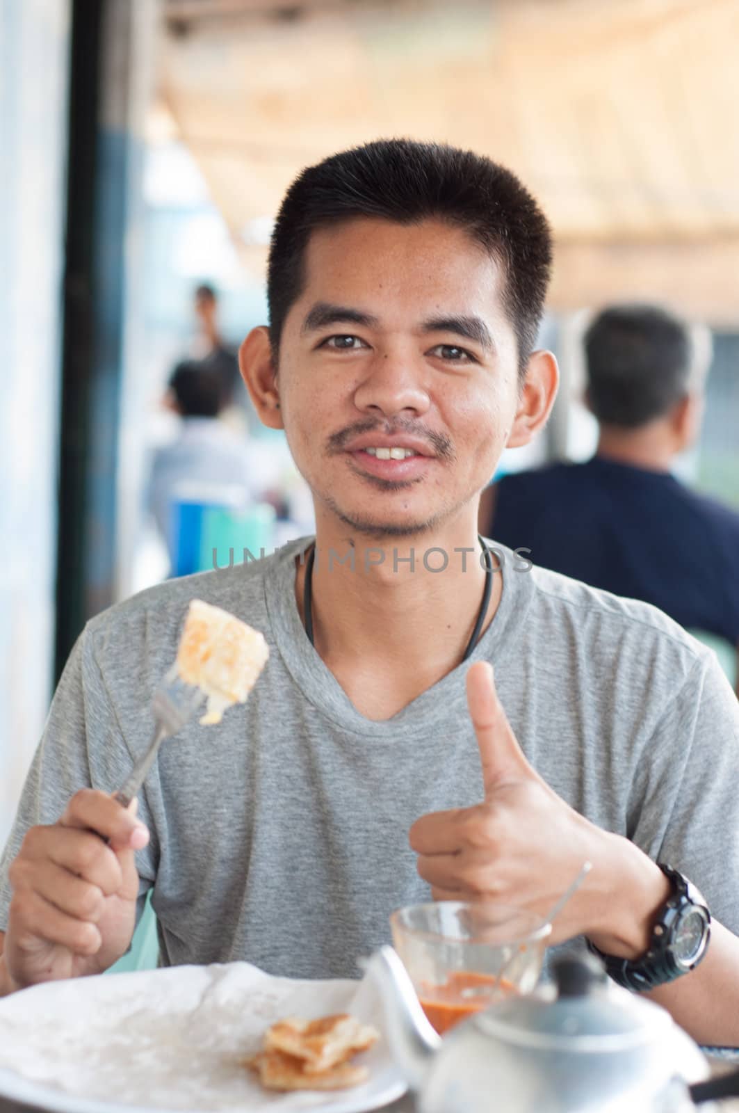 asian man enjoy eating breakfast