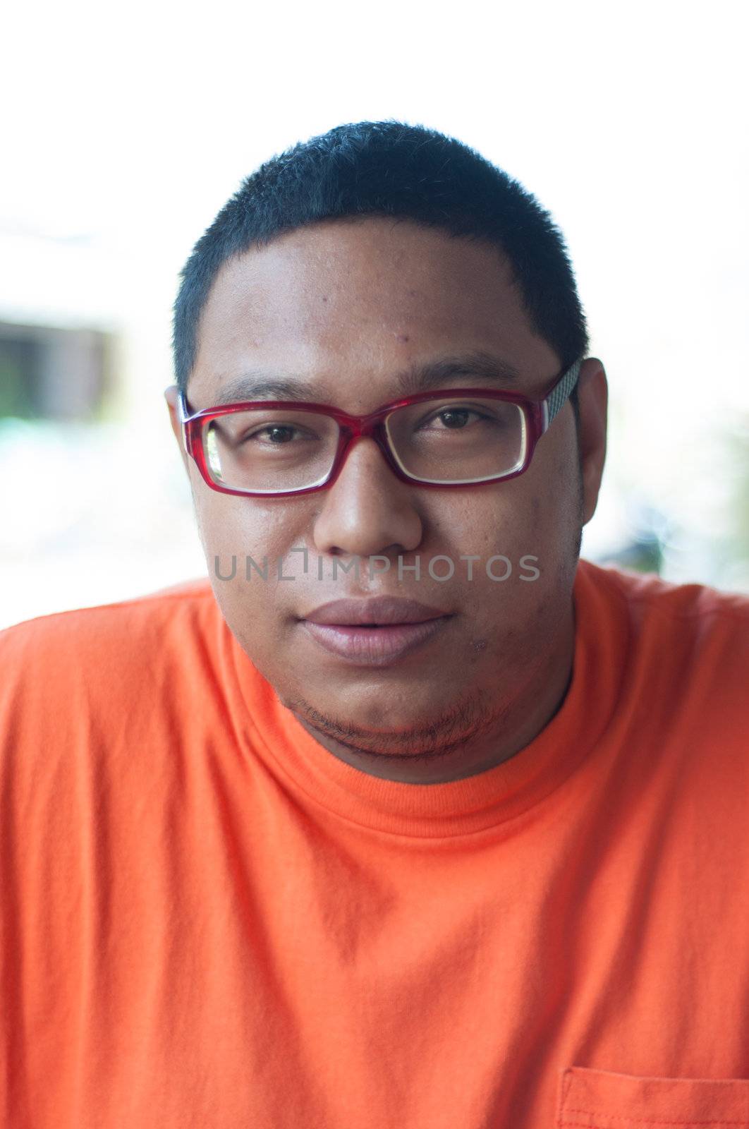 asian man wearing glasses portrait in orange shirt