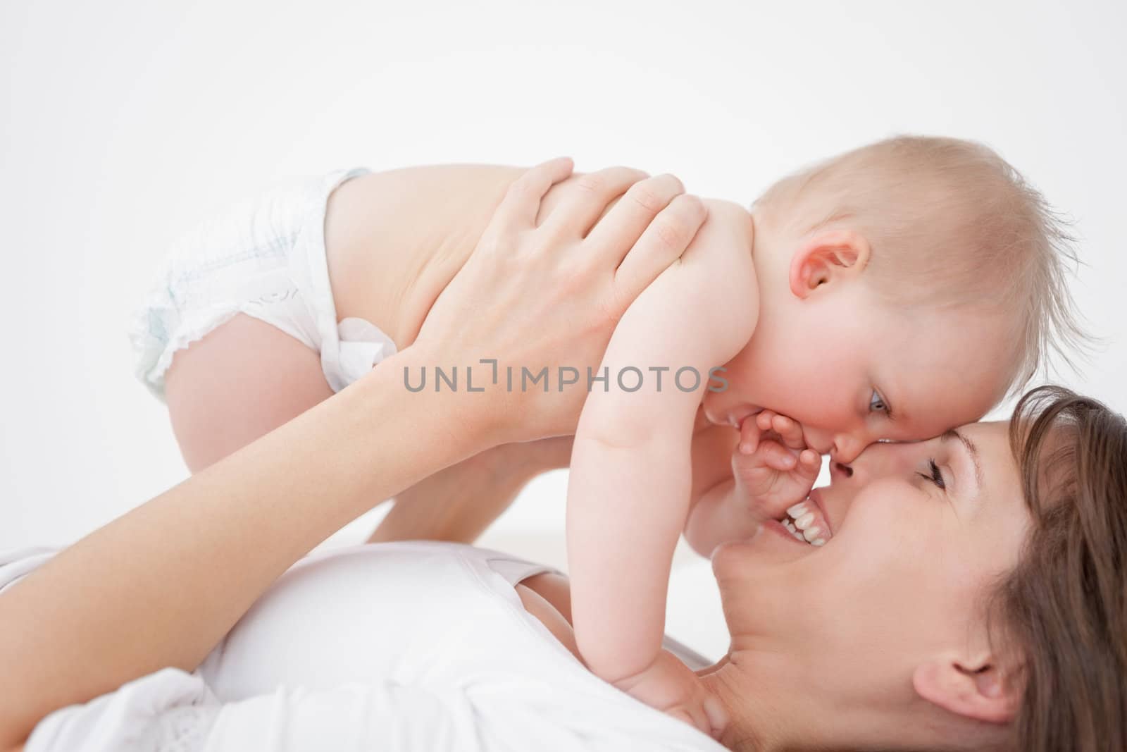 Happy mother holding her daughter while lying by Wavebreakmedia
