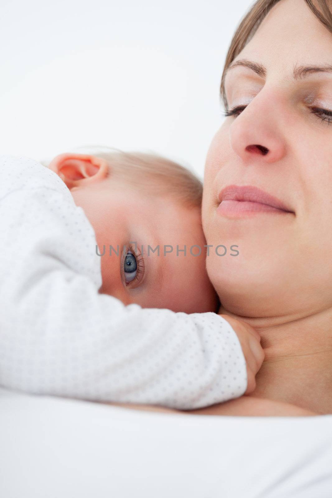 Peaceful baby lying on the chest of her mother indoors