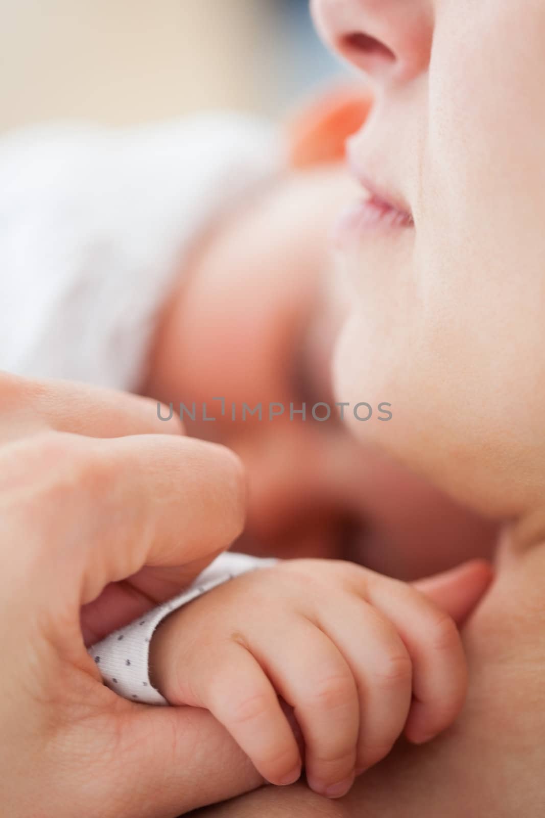 Peaceful woman lying while holding her cute baby indoors