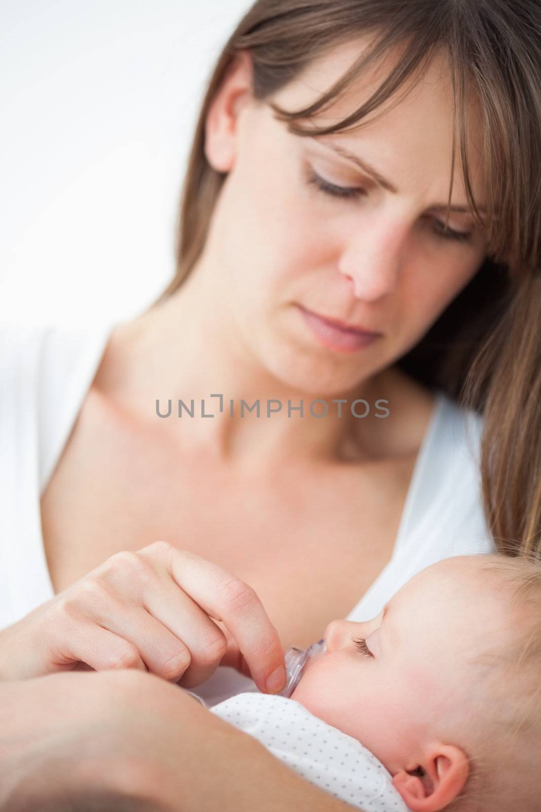 Serious woman giving a pacifier to her daughter by Wavebreakmedia