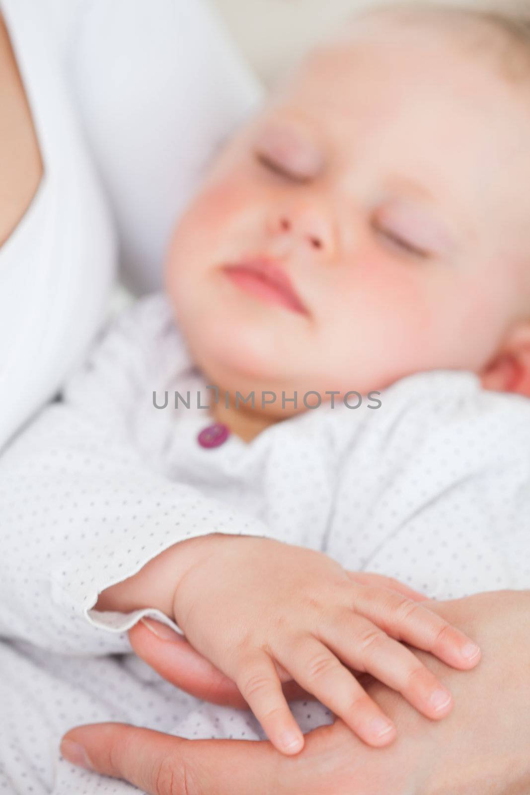 Peaceful baby being held by her mother in a room