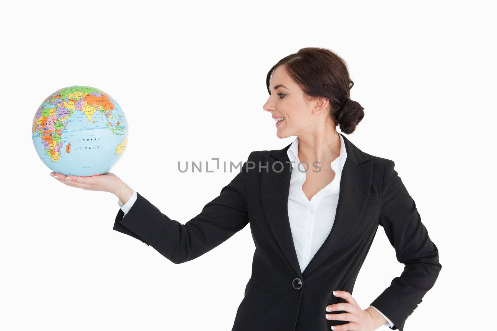 Brunette businesswoman holding an earth globe in her palm against white background