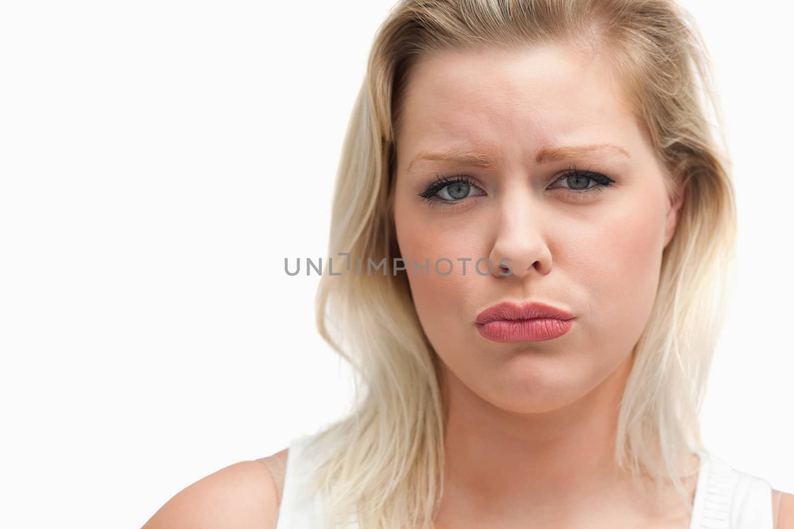 Upset blonde woman staring at the camera against a white background
