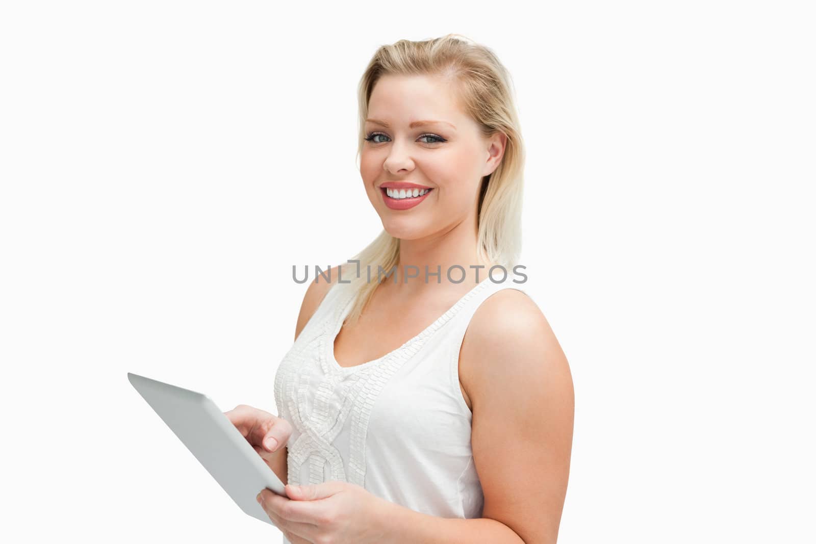 Cheerful blonde woman holding her tablet computer against a white background