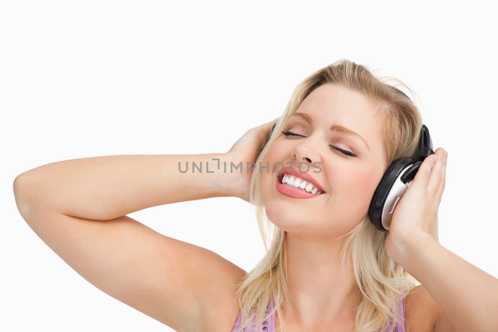 Woman listening to music while closing her eyes against a white background