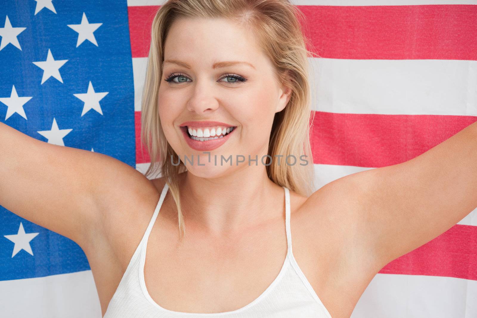 Cheerful woman holding the American flag in a studio