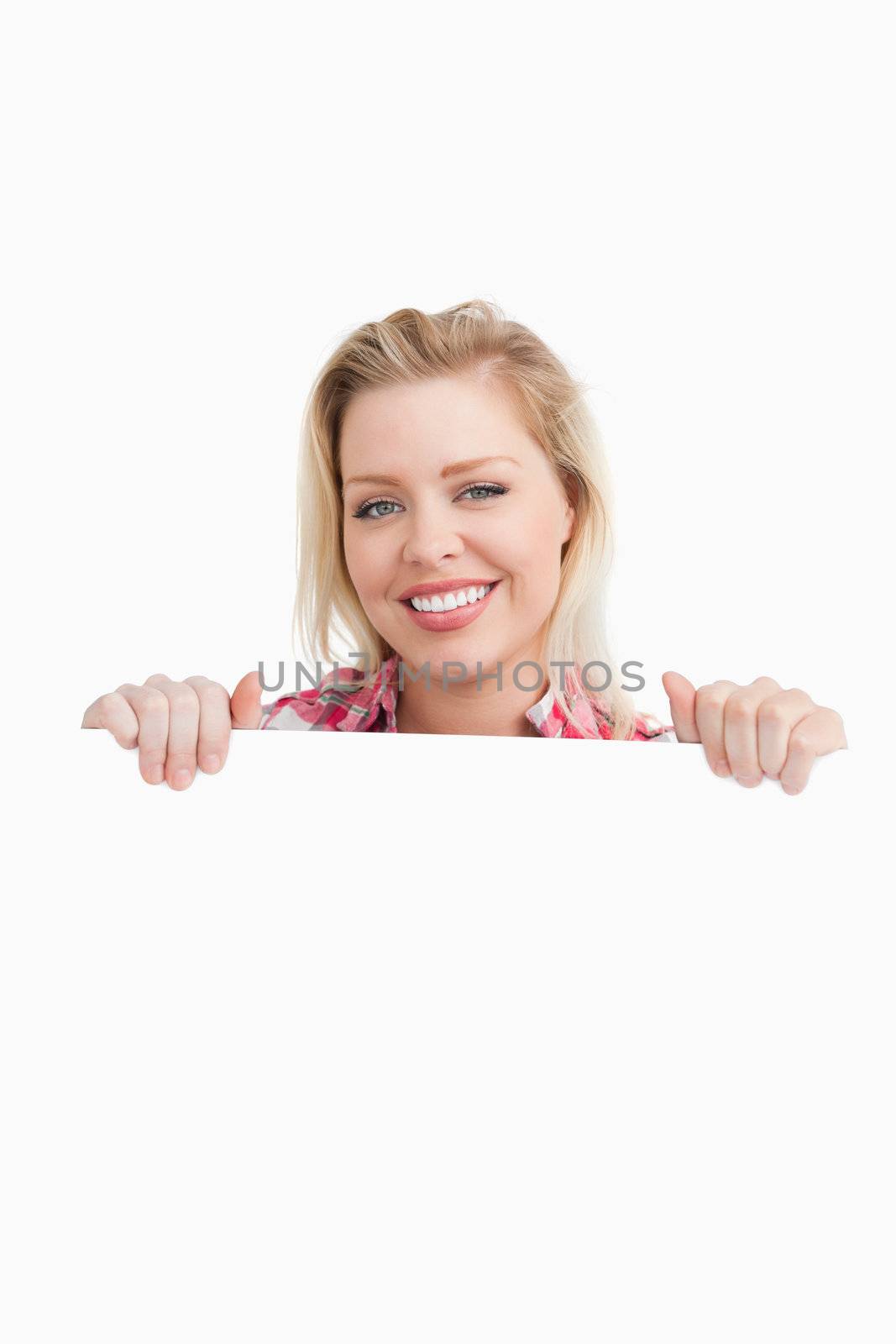 Happy woman holding a blank placard against a white background