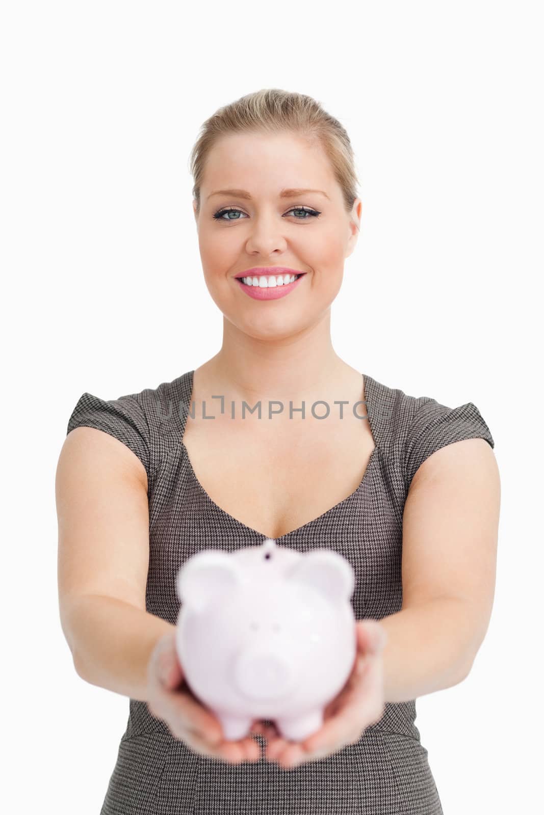 Piggy bank showing by a pretty woman against white background