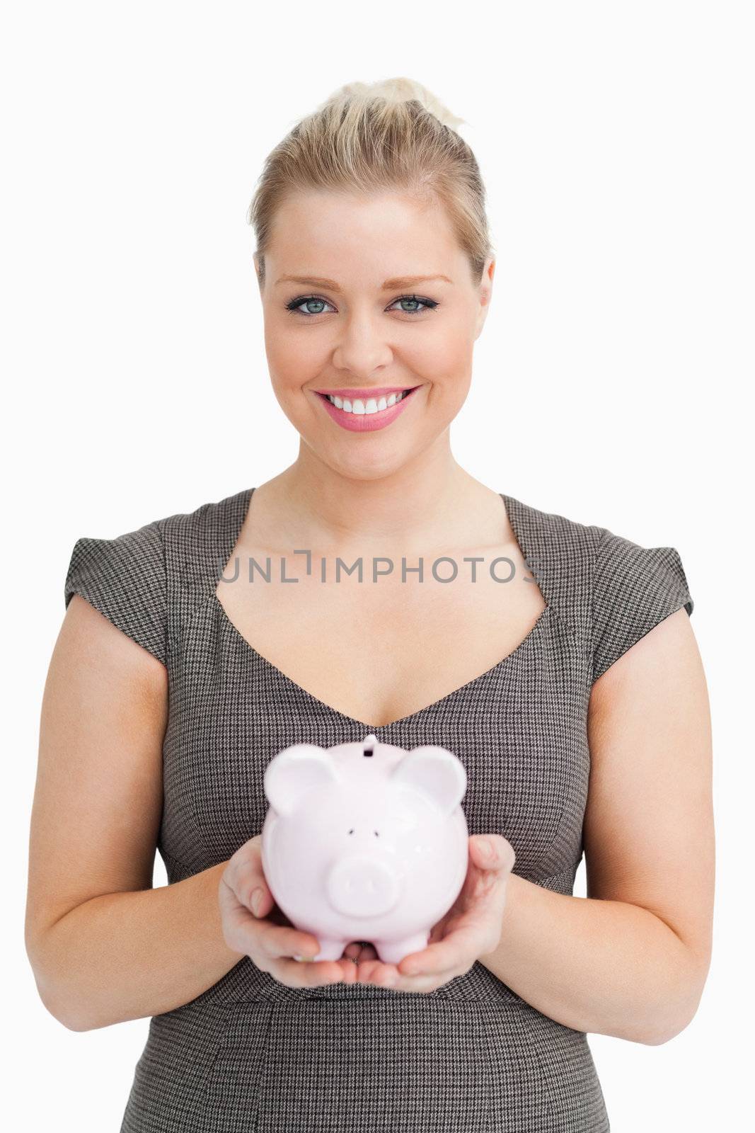 Woman showing a pink piggy bank against white background