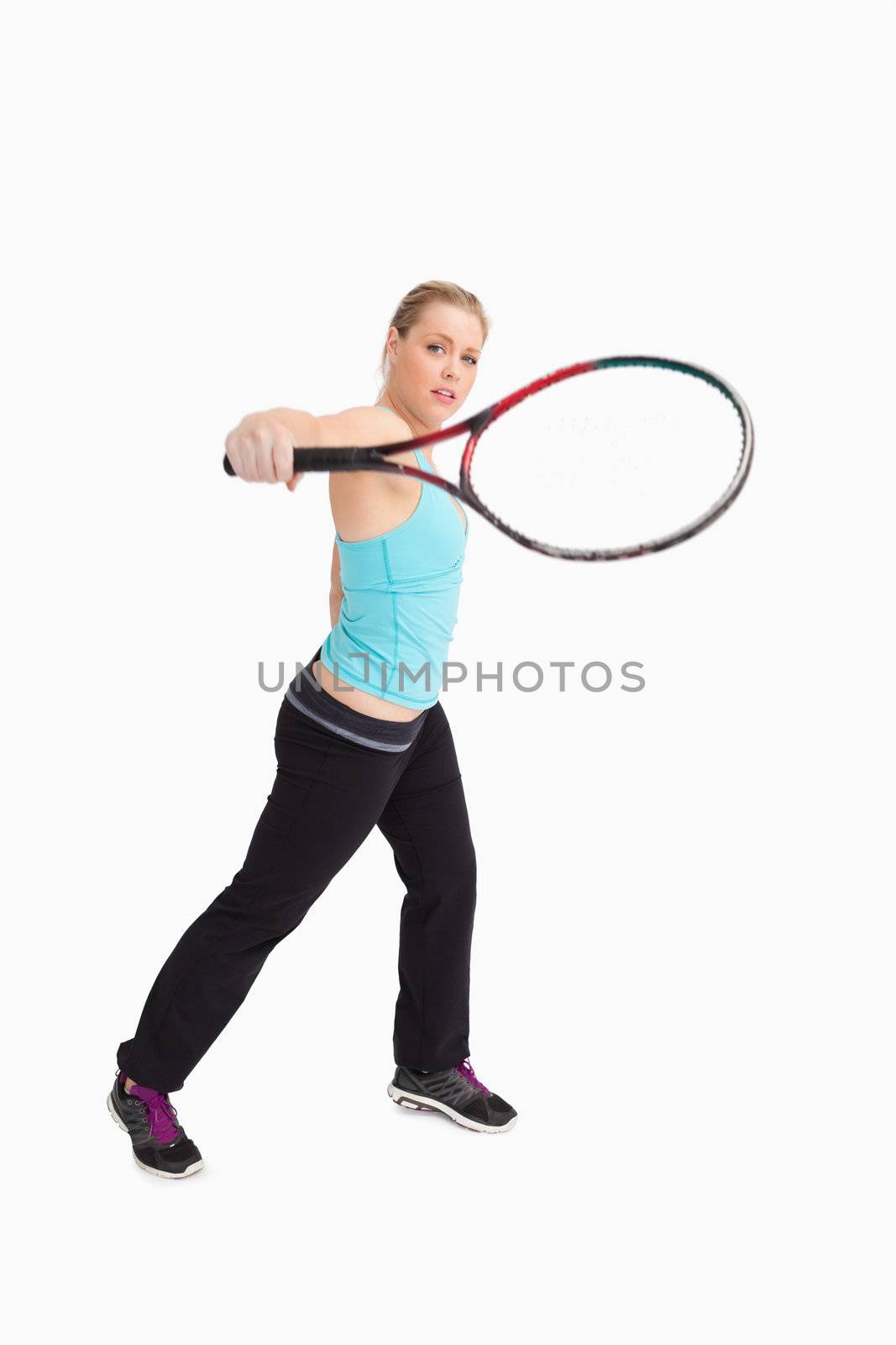 Woman playing tennis with a racket against white background
