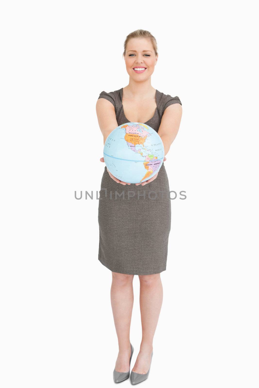 Woman smiling showing a globe against white background