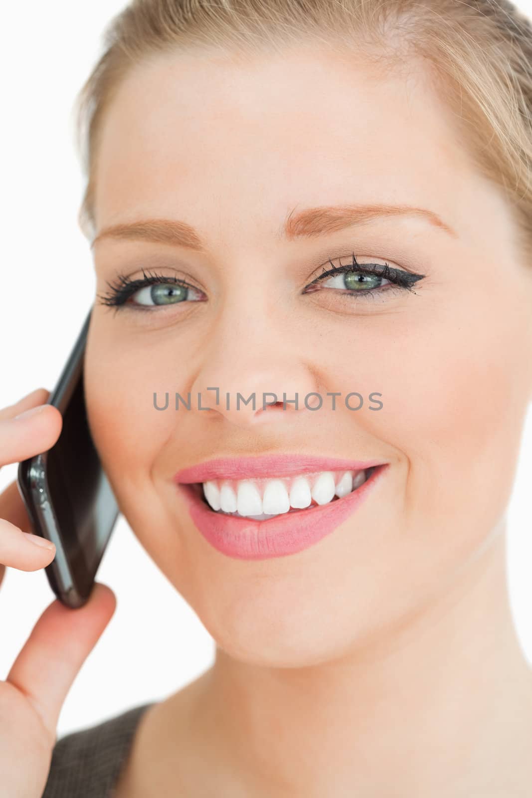 Woman smiling calling with her smartphone against white background