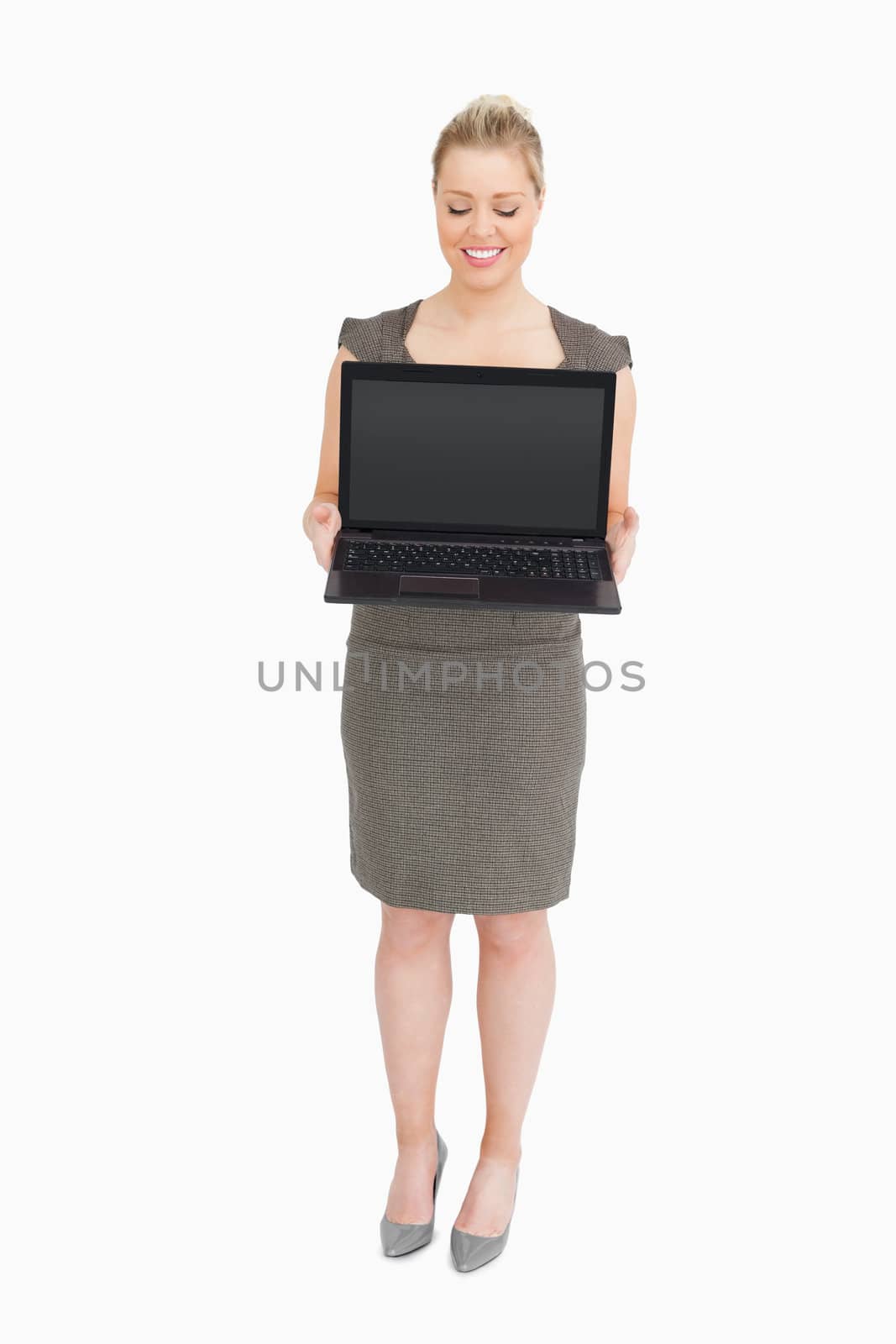 Businesswoman showing a laptop against white background