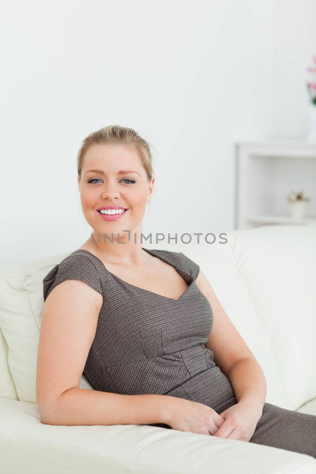 Woman smiling while sitting on a sofa in a lounge