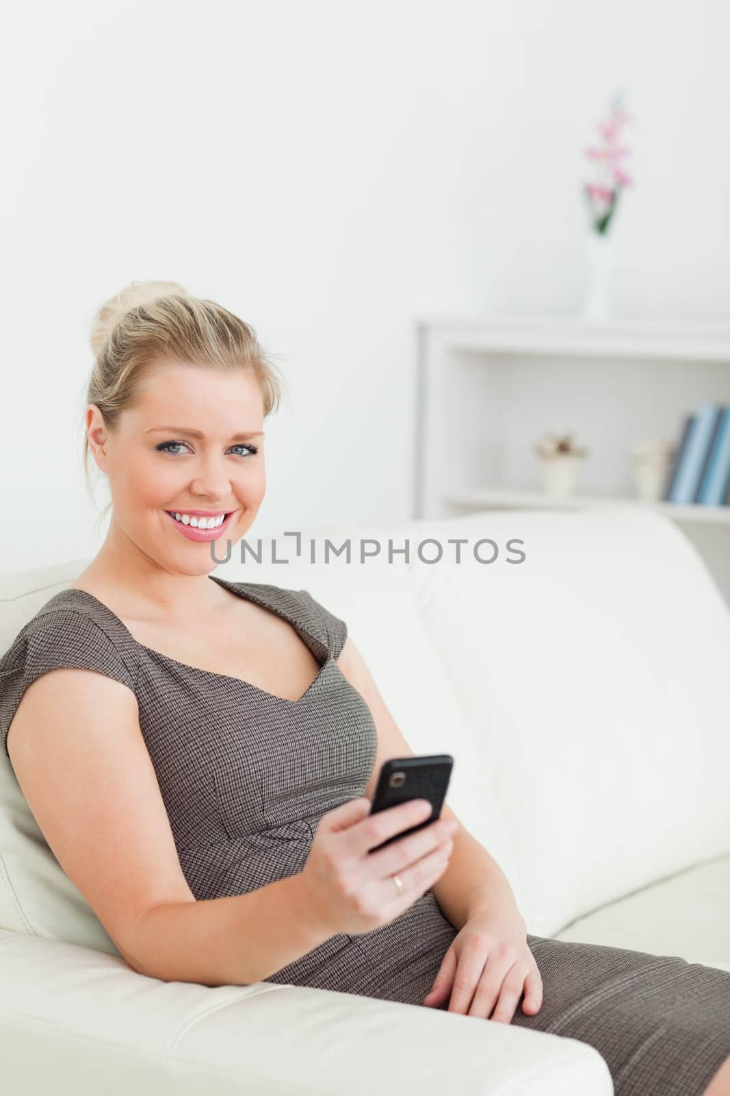 Woman sitting on a sofa using her phone in a lounge