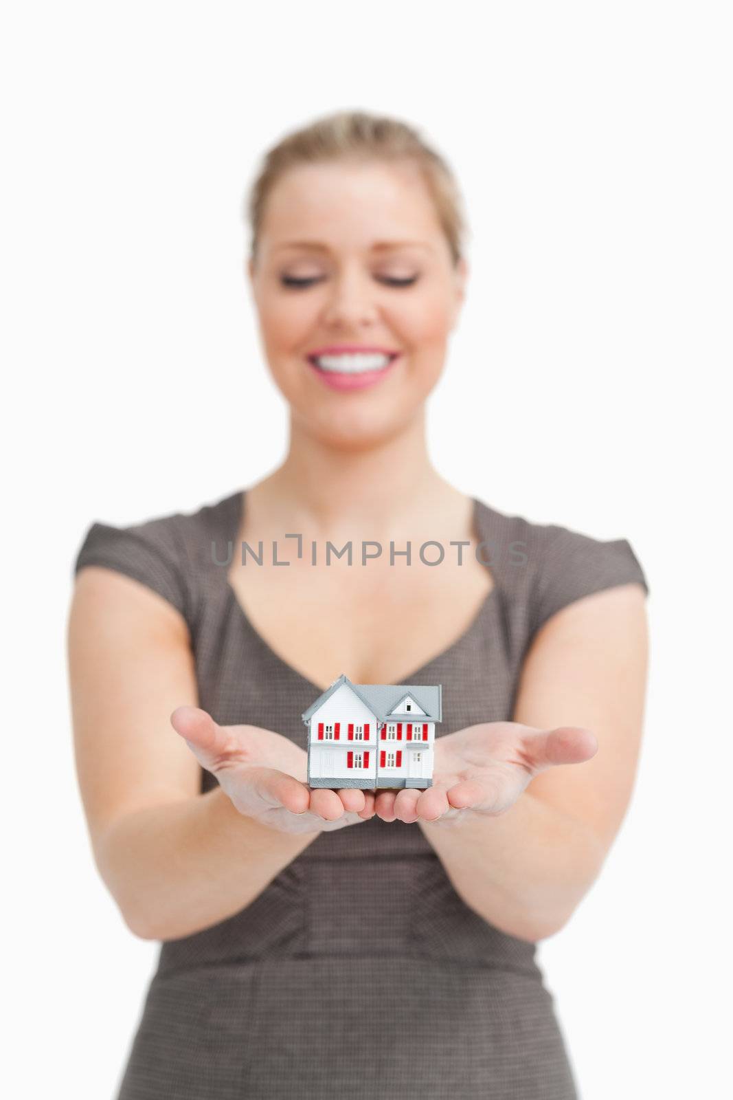 Woman looking a little model house on her hands against white background