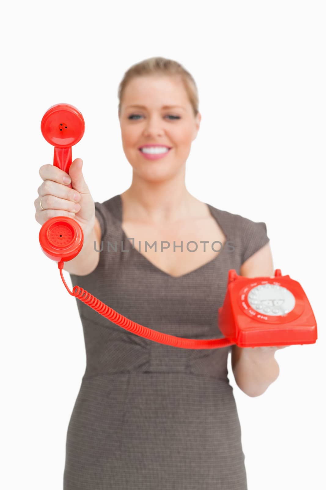 Woman showing a retro phone against a white background