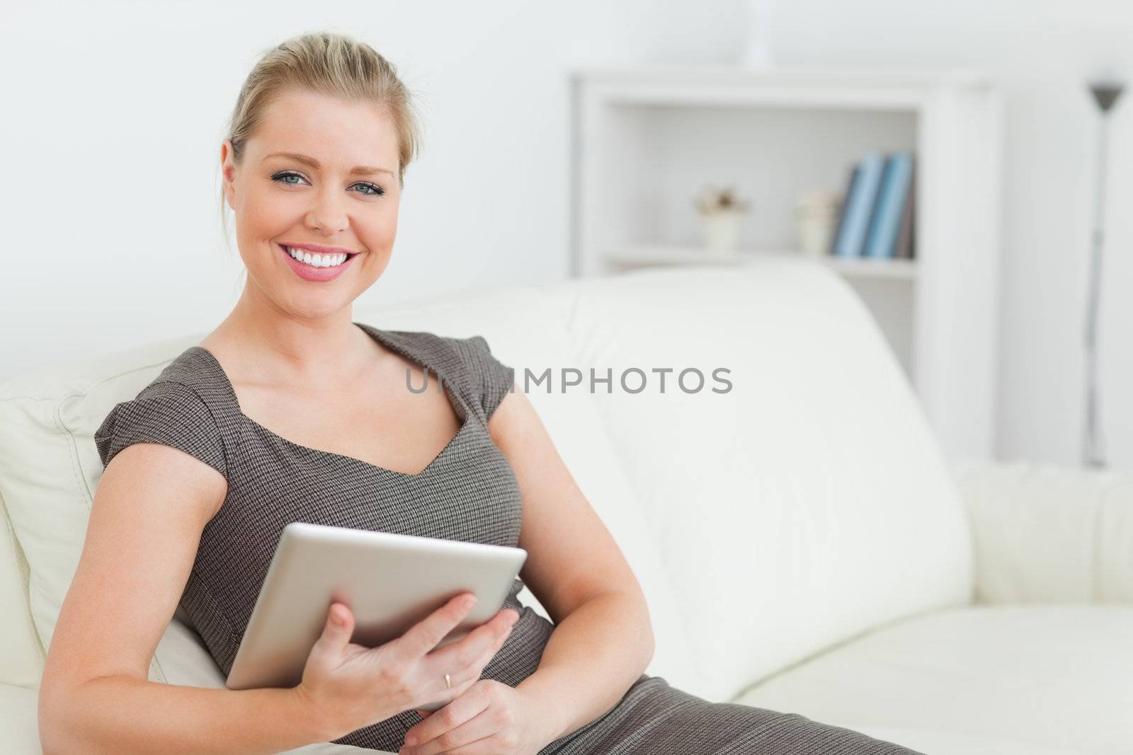 Woman holding an ebook sitting on a sofa